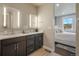Well-lit bathroom featuring dual sinks, sleek fixtures, and a bedroom view at 15776 Native Willow Dr, Monument, CO 80132