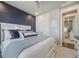 Stylish bedroom featuring a cozy bed, a navy accent wall, and a glimpse into the hallway at 15776 Native Willow Dr, Monument, CO 80132
