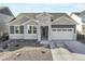 Charming single Gathering home featuring a stone facade, well-manicured lawn, and an attached two-car garage at 15776 Native Willow Dr, Monument, CO 80132