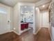 Hallway view showcasing hardwood floors and a glimpse into the bright and functional office space with built-ins at 15776 Native Willow Dr, Monument, CO 80132