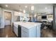 Kitchen showcasing a large island with seating, a farmhouse sink, and open access to the living room area at 15776 Native Willow Dr, Monument, CO 80132