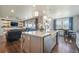 Open kitchen layout with a farmhouse sink island, quartz countertops, and seamless flow to the living and dining areas at 15776 Native Willow Dr, Monument, CO 80132