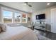 Bright bedroom featuring multiple windows, a ceiling fan, and a sleek TV stand at 15776 Native Willow Dr, Monument, CO 80132