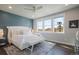 Bright main bedroom featuring large windows, a cozy bed, and an accent wall at 15776 Native Willow Dr, Monument, CO 80132