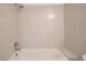 Bathroom featuring a tiled shower over tub with updated fixtures and a neutral color palette at 1533 E Harlan, Lakewood, CO 80214