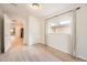 Bedroom with light wood floors, view leading into the kitchen, and a window with natural light at 1533 E Harlan, Lakewood, CO 80214