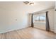 A bright bedroom with light wood floors, a window with curtains, and neutral walls at 1533 E Harlan, Lakewood, CO 80214