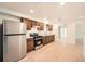 Modern kitchen with stainless steel appliances, wood cabinets, and bright countertops and light wood floors at 1533 E Harlan, Lakewood, CO 80214