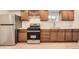 Well-lit kitchen featuring stainless steel appliances, light countertops, wood cabinets, and light wood floors at 1533 E Harlan, Lakewood, CO 80214