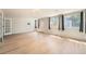 Open-concept living room with light wood floors, natural light from large windows, and a glass door at 1533 E Harlan, Lakewood, CO 80214