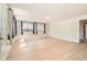Bright living room with light wood floors, multiple windows, and a glass door entrance at 1533 E Harlan, Lakewood, CO 80214