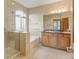 Bright bathroom featuring a glass-enclosed shower, soaking tub, double sinks, and tiled floors at 16231 Rayburn St, Hudson, CO 80642