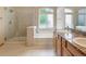 Bathroom with double sinks, large soaking tub, and separate glass-enclosed shower at 16231 Rayburn St, Hudson, CO 80642