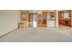 Spacious living room with transition to entry area, hardwood floors and modern kitchen at 16231 Rayburn St, Hudson, CO 80642
