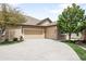 Beige home featuring an attached garage and spacious driveway at 6193 Terry Ct, Arvada, CO 80403