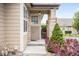 Inviting front porch with brick accents and well-manicured shrubs at 6193 Terry Ct, Arvada, CO 80403