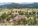 Panoramic aerial view of the home nestled amongst lush trees and nature at 6640 Kilimanjaro Dr, Evergreen, CO 80439