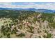 Distant aerial of the home and surrounding wooded mountain range at 6640 Kilimanjaro Dr, Evergreen, CO 80439