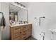 Modern bathroom with a wood vanity, matte black fixtures, and a large mirror at 6640 Kilimanjaro Dr, Evergreen, CO 80439