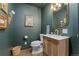 Stylish powder room with unique wall art, wood vanity, and gold fixtures at 6640 Kilimanjaro Dr, Evergreen, CO 80439