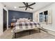 Charming bedroom with dark accent wall, ceiling fan, and bright window at 6640 Kilimanjaro Dr, Evergreen, CO 80439
