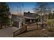Back exterior elevation of mountain home with deck and an attached garage at 6640 Kilimanjaro Dr, Evergreen, CO 80439