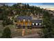 Modern exterior elevation of mountain home, featuring a large deck and steps to driveway at 6640 Kilimanjaro Dr, Evergreen, CO 80439