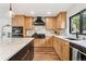 Modern kitchen boasts wood cabinets, marble countertops, and professional-grade black stainless steel appliances at 6640 Kilimanjaro Dr, Evergreen, CO 80439