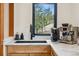 Coffee station with a marble countertop, black sink and fixtures, and a serene outdoor view at 6640 Kilimanjaro Dr, Evergreen, CO 80439
