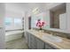 Bright bathroom featuring double sinks, a large mirror, and a separate bathtub and shower area at 6 Timberlake Ct, Byers, CO 80103