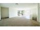 Open-concept living room with neutral carpeting and a view into the modern kitchen and backyard at 6 Timberlake Ct, Byers, CO 80103