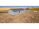 Rear exterior of a well-maintained single-story home with a detached garage in a rural setting at 6 Timberlake Ct, Byers, CO 80103