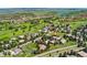 Expansive aerial view of a golf community with lush greenery and stunning mountain scenery at 6457 Willow Broom Trl, Littleton, CO 80125