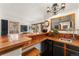 Inviting bar area with tile countertop, sink, mini refrigerator, and rustic chandelier at 6457 Willow Broom Trl, Littleton, CO 80125