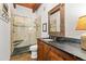 Bathroom featuring granite countertop vanity, decorative mirror, and tiled shower with bench at 6457 Willow Broom Trl, Littleton, CO 80125