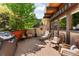 Spacious deck with comfortable seating, lush greenery, and a grill, perfect for outdoor entertaining at 6457 Willow Broom Trl, Littleton, CO 80125