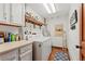 Efficient laundry room with white washer and dryer, ample shelving, and a practical countertop at 6457 Willow Broom Trl, Littleton, CO 80125