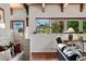 Comfortable living room with exposed wood beams, white brick accents, and large, view-filled windows at 6457 Willow Broom Trl, Littleton, CO 80125