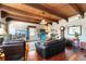 Living room featuring exposed beam ceiling, hardwood floors, and bright natural light from multiple windows at 6457 Willow Broom Trl, Littleton, CO 80125