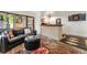 Comfortable living room featuring a leather sofa, ottoman, and stone bar with sink at 6457 Willow Broom Trl, Littleton, CO 80125
