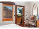 Bedroom featuring wood trim window, patio access, and exercise bicycle at 6457 Willow Broom Trl, Littleton, CO 80125