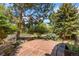 Landscaped patio with stone pavers, bench seating, and mature trees for shade at 6457 Willow Broom Trl, Littleton, CO 80125