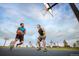 Two men are playing basketball on an outdoor court with a blue sky and clouds overhead at 171 S Waterloo St, Aurora, CO 80018