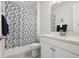 A clean bathroom with a decorative shower curtain, white vanity, and modern fixtures at 171 S Waterloo St, Aurora, CO 80018