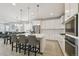 Bright, open kitchen with white cabinets, an island with seating, and stainless steel appliances at 171 S Waterloo St, Aurora, CO 80018