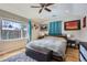 Sun-filled bedroom featuring a comfortable bed, bench, and ample natural light from the window at 2901 N Glencoe St, Denver, CO 80207