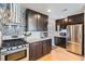 Stylish kitchen with stainless steel appliances, granite countertops, and dark wood cabinets at 2901 N Glencoe St, Denver, CO 80207