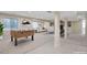 Staged basement featuring foosball table, living area, large windows, and neutral palette at 20271 E Lake Ave, Centennial, CO 80016