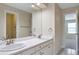 Bathroom featuring dual sinks with brushed nickel fixtures, a large mirror and decorative tile at 20271 E Lake Ave, Centennial, CO 80016