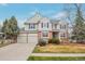 A two-story home with a brick and siding exterior, a three-car garage, and mature landscaping at 20271 E Lake Ave, Centennial, CO 80016